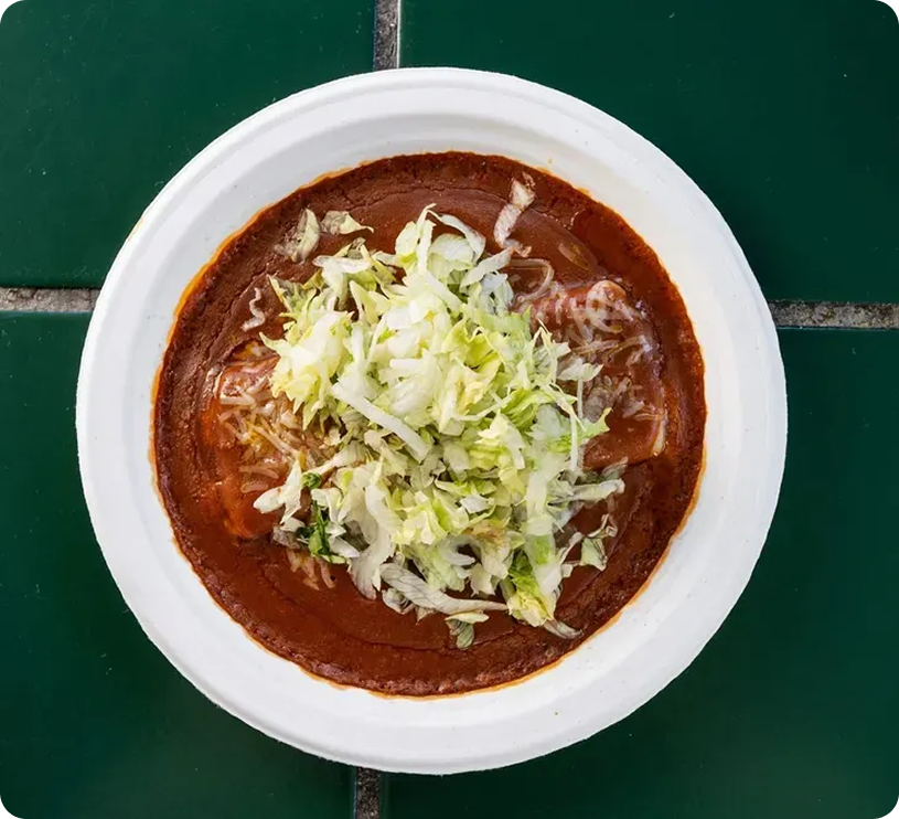 Plate of enchiladas topped with shredded lettuce.